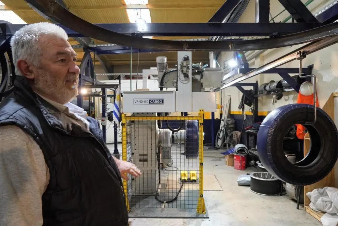 Adrián Guerra junto a la máquina VR 50-130 Cargo en la planta de Neumáticos del Sur