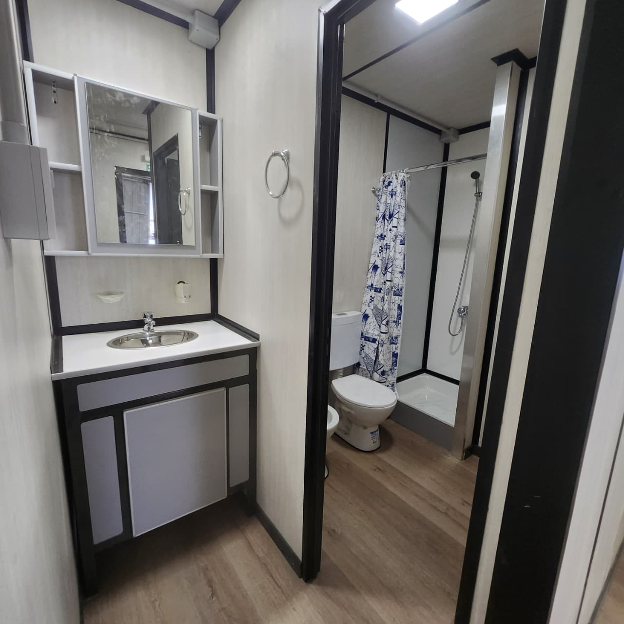 Baño del módulo con vanitory, espejo y ducha con terminación industrial